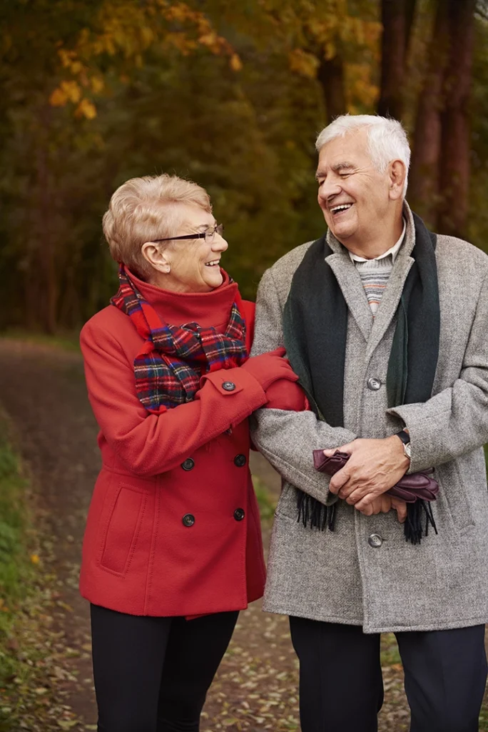 Couple de retraités se promenant dans un décor automnal